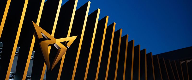 Ein CUPRA Logo auf einem bronzefarbenen Zaun