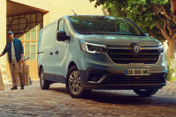 Der Renault Trafic steht vor einem Handwerker mit Paketen