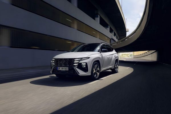 Ein Hyundai TUCSON fährt durch eine Kurve unter einer Brücke